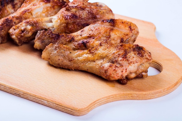 Grilled chicken drumstick on a wooden plate