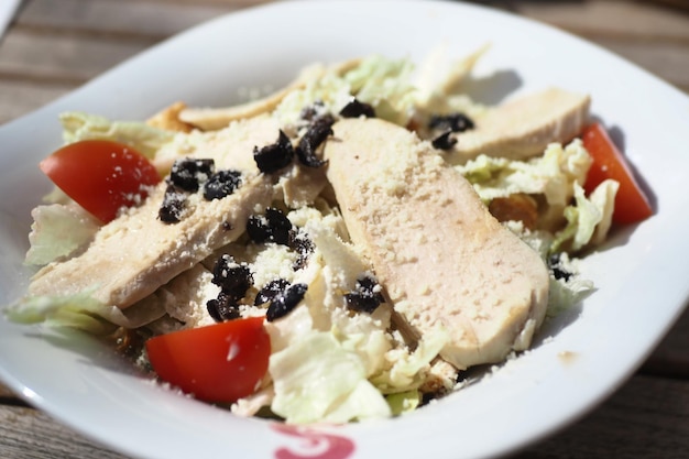 Grilled chicken and fresh vegetable salad on table