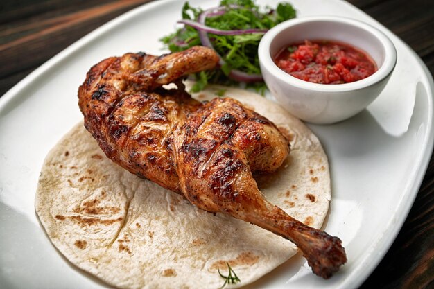 Grilled chicken half with sauce and herbs