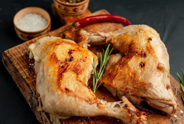 grilled chicken legs with spices and herbs, ready for cooking on a stone background.