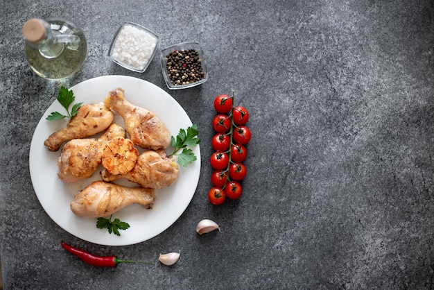 grilled chicken legs with spices on a stone background