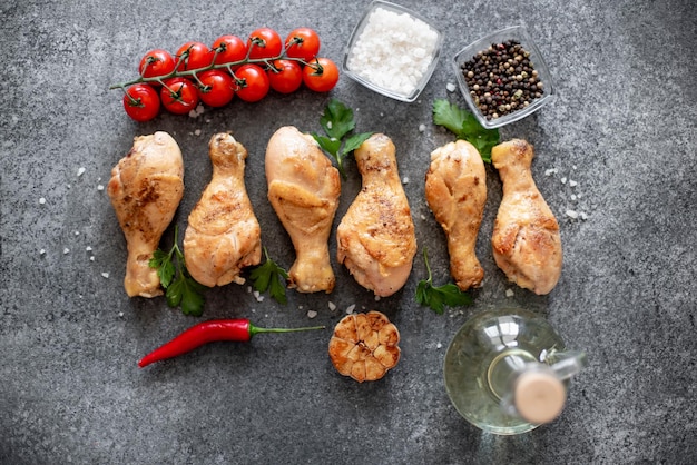 grilled chicken legs with spices on a stone background