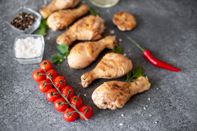 grilled chicken legs with spices on a stone background