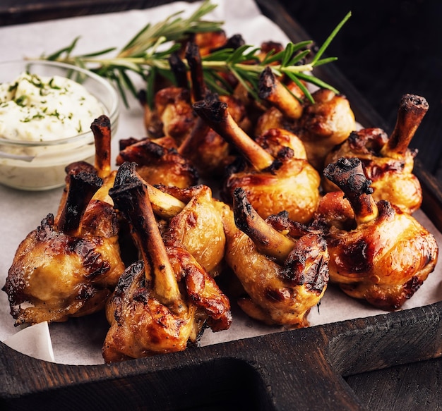 Grilled chicken legs on wooden tray