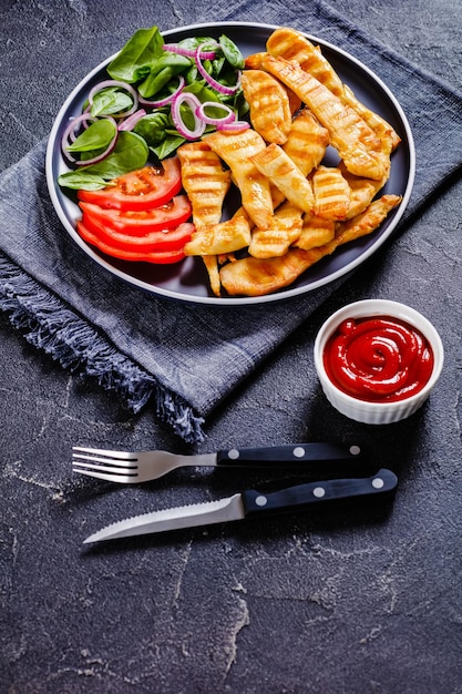 Grilled chicken strips on a plate with vegetables