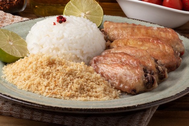 Grilled chicken wings served with rice and toasted manioc flour