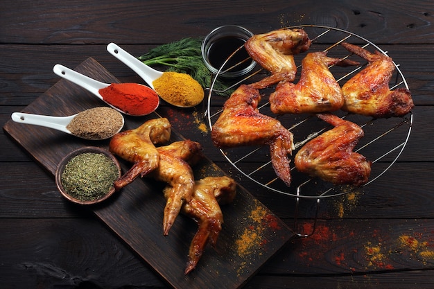 grilled chicken wings and spices on a wooden table