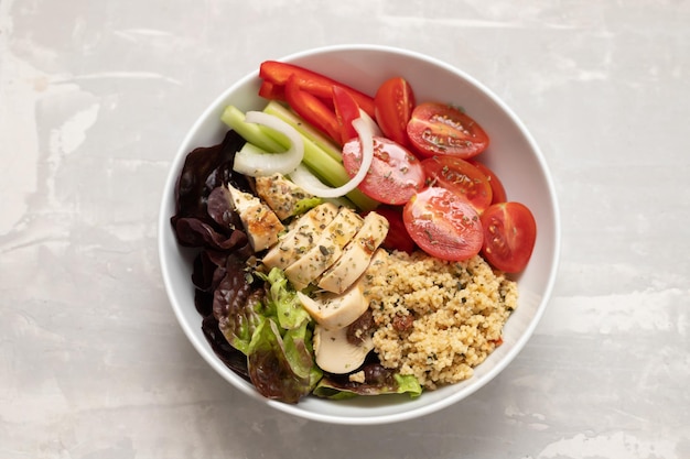 Grilled chicken with salad tabbouleh and fresh vegetables in the bowl