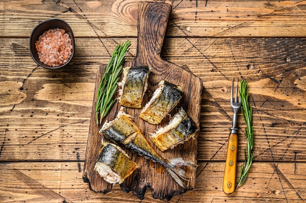 Grilled cut mackerel fish on cutting board. wooden table. Top view.