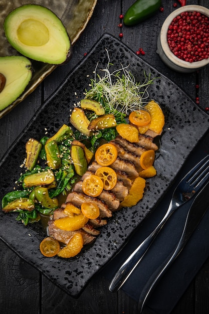 Grilled duck fillet with green salad, avocado and baked kumquat