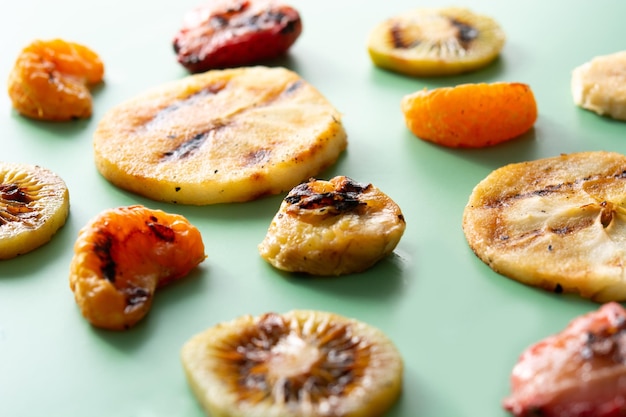 Grilled fruit for summer on green background