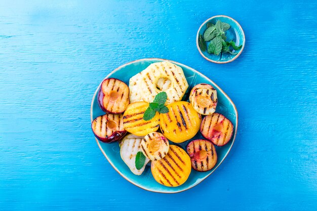 Grilled fruits with mint leaves on a plate