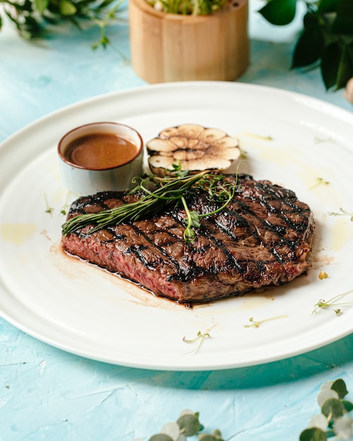 Grilled juicy beef steak medium roast with rosemary and pepper sauce