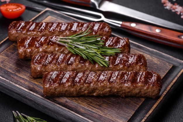 Grilled kebab with spices and herbs on a dark concrete background