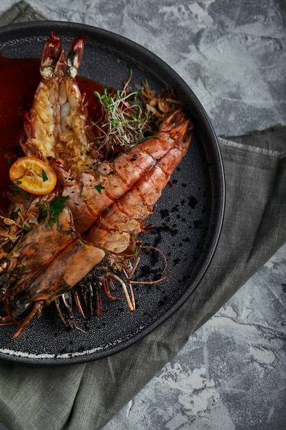 Grilled king prawns, with tomato sauce on a gray space, low key. Series concrete space. Food concept, food style, Copy space, food advertising for magazines and social networks.