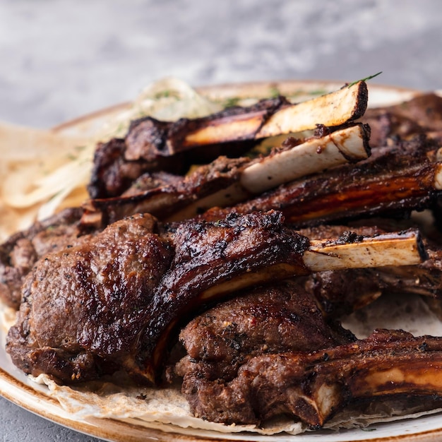 Grilled lamb meat on a plate. Closeup