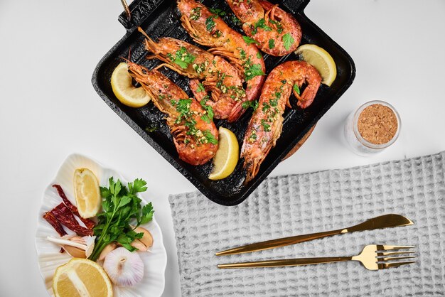 Photo grilled large queen shrimps with lemon and spices on grill pan