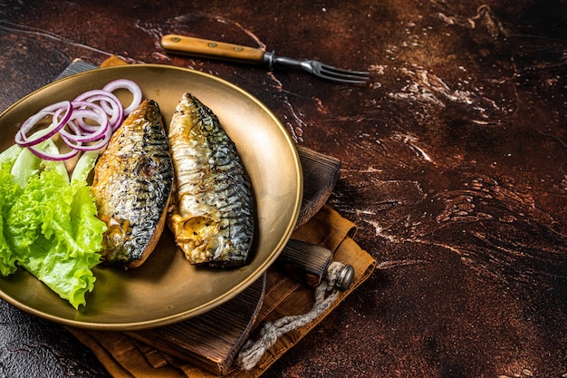 Grilled mackerel scomber fish fillets with garnish in a plate Dark background Top view Copy space