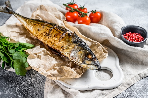 Grilled mackerel with parsley and cherry tomatoes. Gray background. Top view