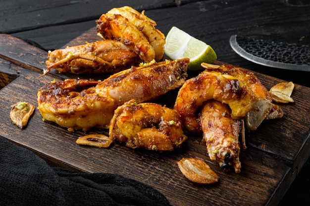 Grilled Mango Prawns or shrimps set, on wooden board, on black wooden table background