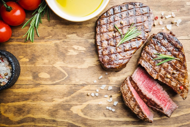 Grilled marbled meat steak Filet Mignon with seasonings. Juicy beef steak on cutting board, top view.