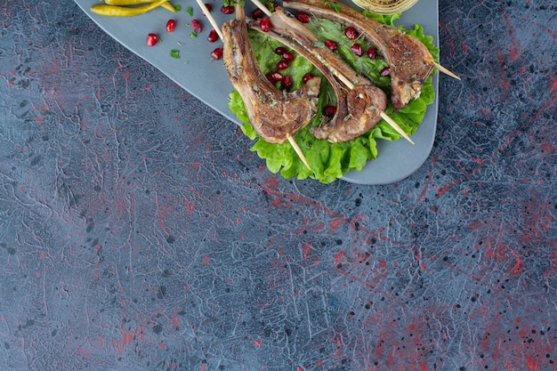 Grilled meat lambs and roasted vegetables on marble table.