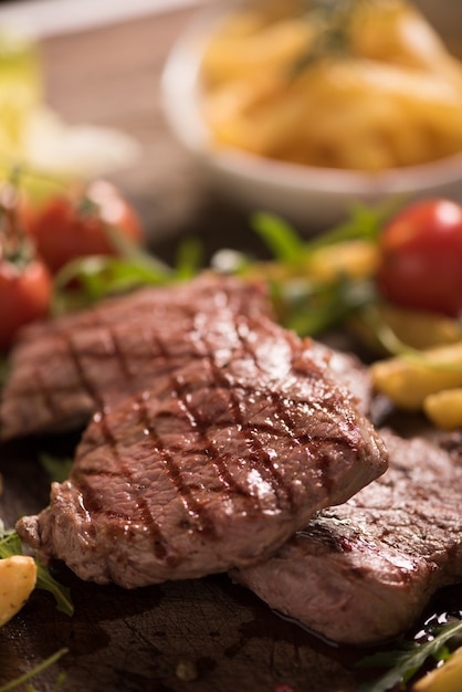 Grilled meat with herbs on wooden board