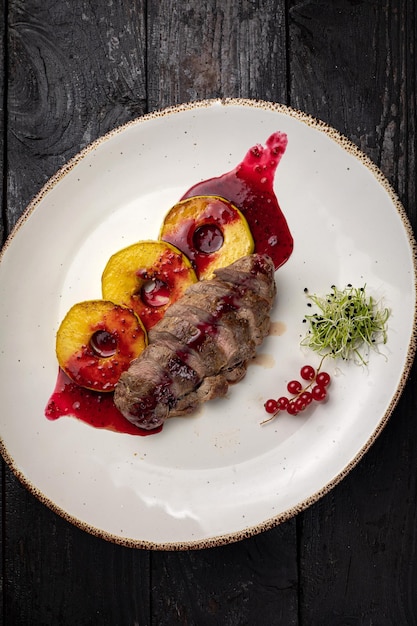 grilled meat with vegetables and spices on a black background