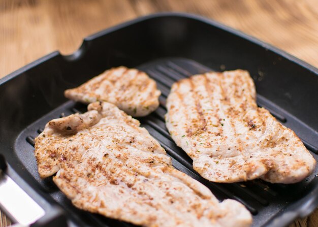 Grilled meat on a wooden frying pan