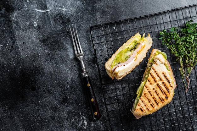 Photo grilled panini with prosciutto ham salad and cheese black background top view copy space