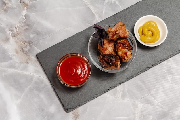 Grilled pork in a bowl with basil and sauces