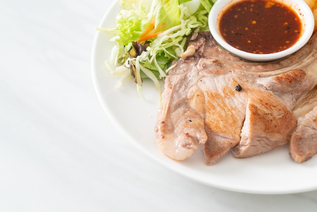 grilled pork chop steak with Thai spicy dipping sauce or Jaew sauce - fusion food style