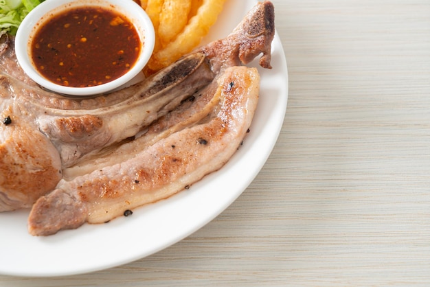 grilled pork chop steak with Thai spicy dipping sauce or Jaew sauce - fusion food style