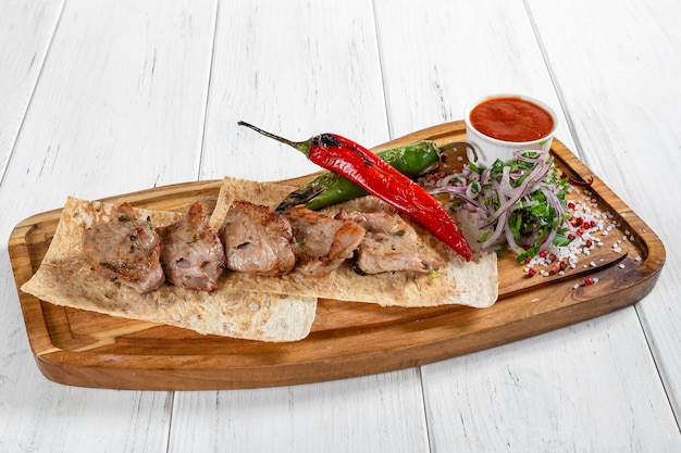 Grilled pork kebab with vegetables and red sauce