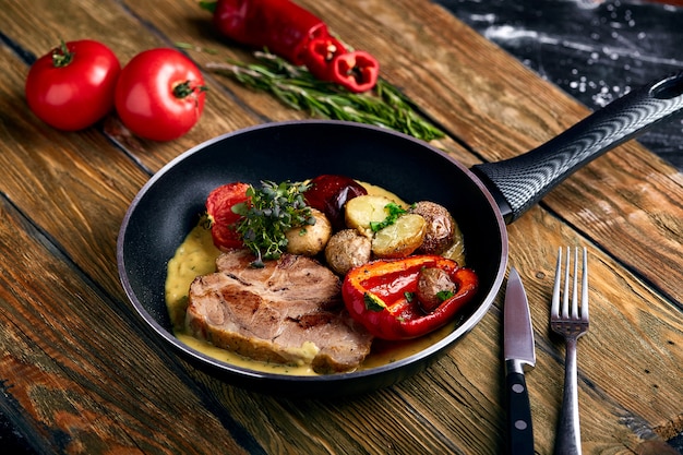 Grilled pork steak with vegetables in a pan