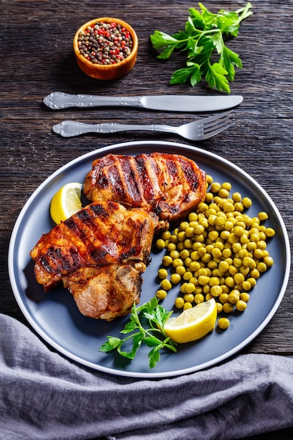 Grilled pork tbone steaks with boiled green peas