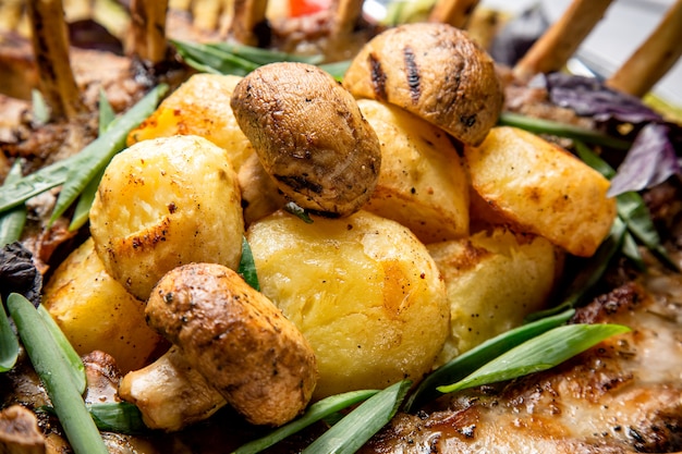 Grilled potatoes and mushrooms with meat and herbs