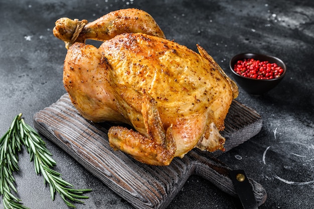 Grilled roasted whole Chicken.  Black background. Top view.