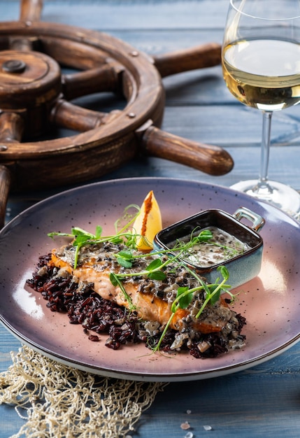 Grilled salmon in a creamy sauce with white mushrooms on a pillow of wild rice