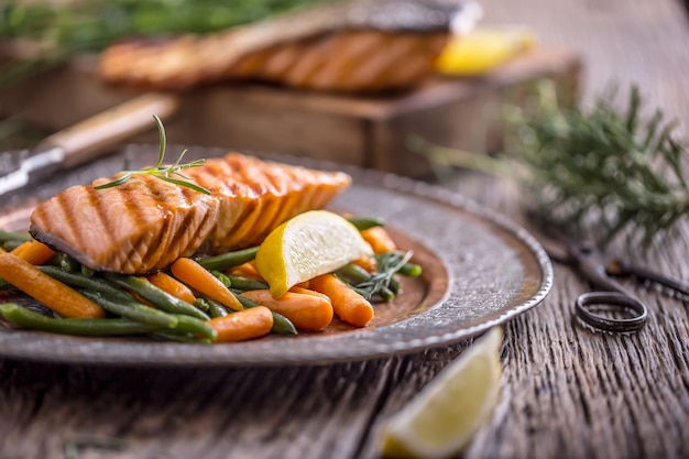 Grilled salmon fillet sesame seeds herb decoration on vintage pan or black slate board