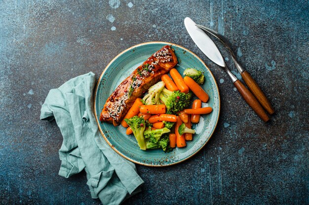 Grilled salmon fillet steak in teriyaki sauce with roasted vegetables carrot and broccoli