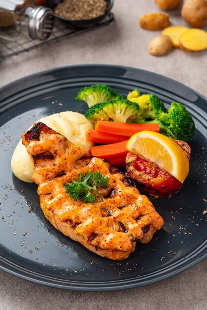 Grilled salmon fillets with mentai sauce and mash potato plating on black plate with negative space