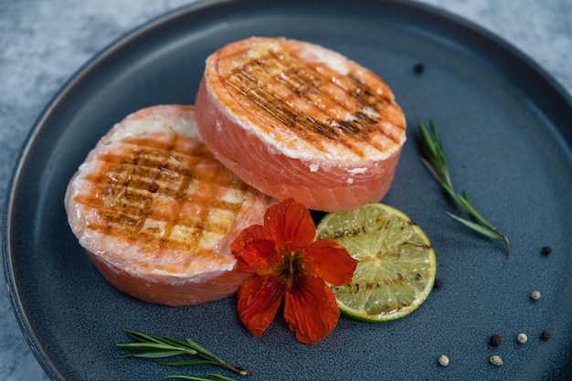 Grilled salmon roll with mozzarella decorated with greens lime and edible flower