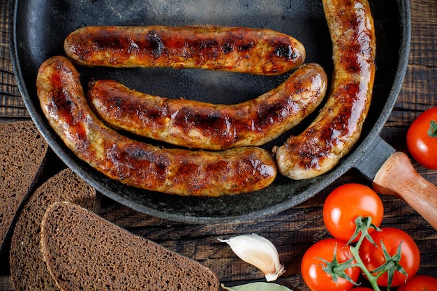 Grilled sausage with herbs and vegetables on the grill outdoors