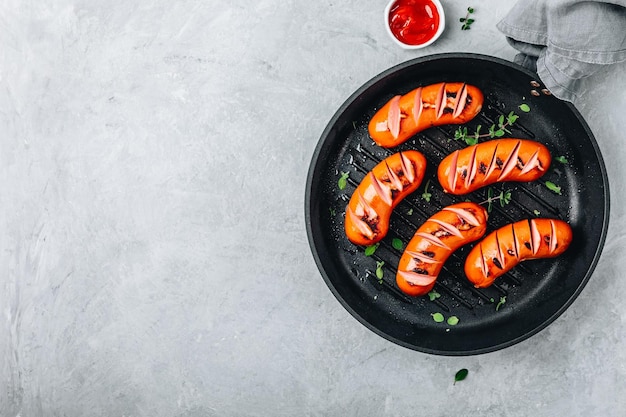 Grilled sausages in cast iron pan Top view