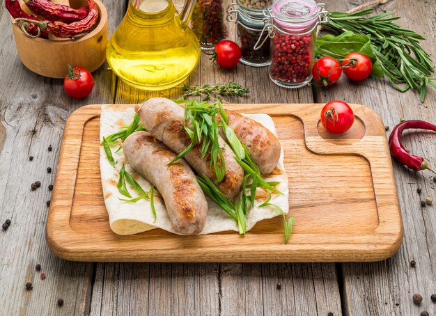 Grilled sausages on the grill on the board