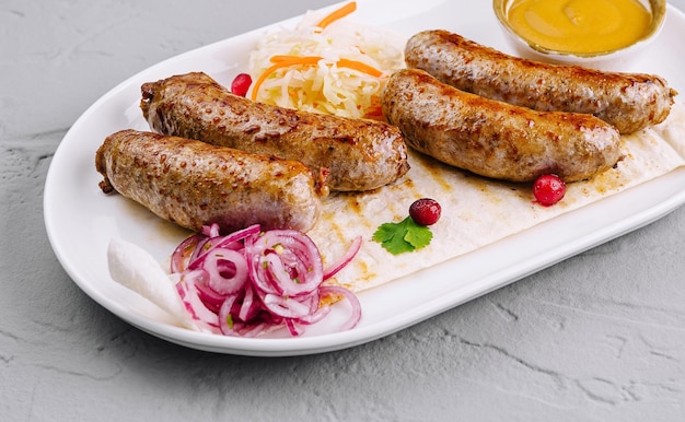 Grilled sausages with sauerkraut and mustard on plate