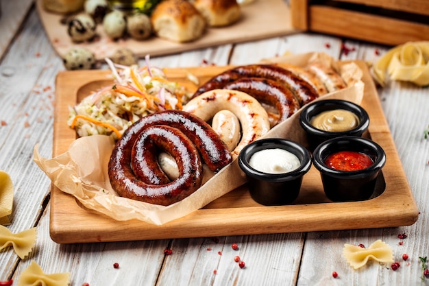 Grilled sausages with sauerkraut and sauces