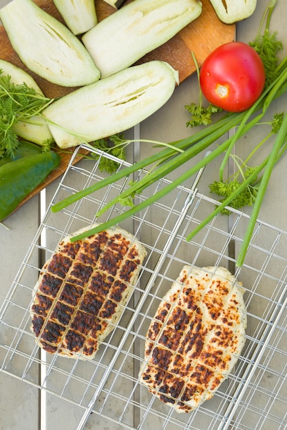 grilled slices of homemade halloumi cheese on grill and salad with eggplant zucchini and herbs