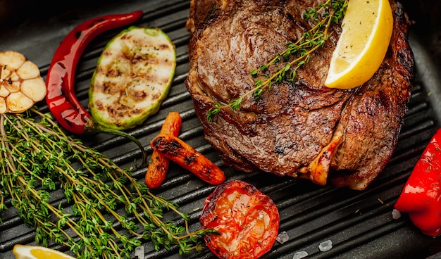 grilled steak in a pan with spices and grilled vegetables on wood! delicious dinner